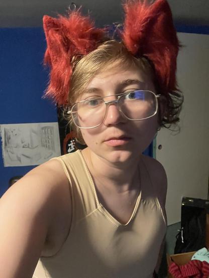 Trans guy with red wolf ears and a chest binder